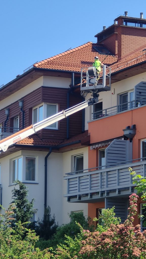 softwash elewacji bloku mieszkalnego – niskociśnieniowe mycie elewacji podczas usuwania zabrudzeń biologicznych